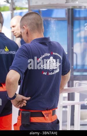 Nahaufnahme von Feuerwehrleuten in blauen und orangen Uniformen, die zusammen stehen, Feuerwehrübung zur Gondelrettung, Deutschland, Europa Stockfoto
