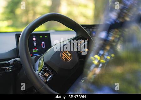 Nahaufnahme des Lenkrads und der Bildschirme im Auto, Bäume und Licht im Hintergrund, MG 4, Deer E- Car Sharing, Bezirk Calw, Deutschland, EU Stockfoto