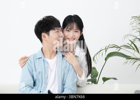 Ein junges Paar, das sich auf dem Sofa umschließt Stockfoto