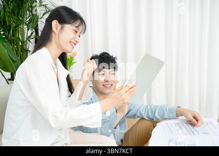 Junge Männer und Frauen, die Tablets und Papierdokumente halten und gemeinsam diskutieren. Stockfoto