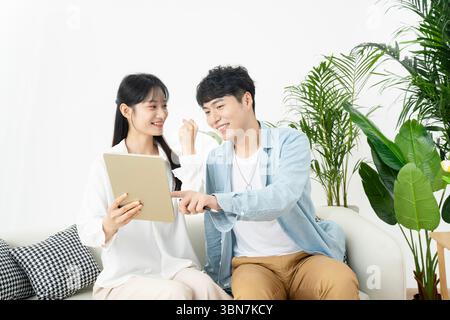 Junge Männer und Frauen, die Tablets und Papierdokumente halten und gemeinsam diskutieren. Stockfoto