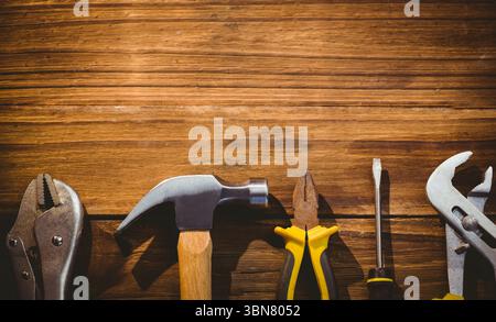 Hammer mit Holzgriff ruht auf rustikaler Plankenbank in flacher Werkstattdarstellung Stockfoto