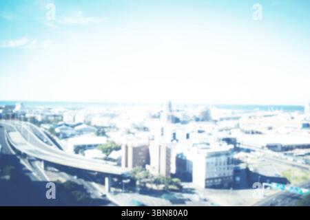 Die Küstenstadt mit flachem Design zeigt mehrspurige Autobahnrampen, die sich durch mittelhohe Häuserblocks kurbeln Stockfoto
