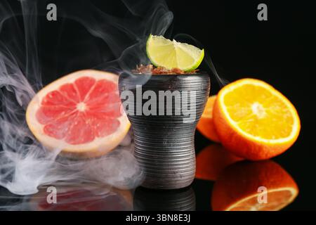 Shisha Schüssel mit Rauch und Früchten auf schwarzem Tisch, Nahaufnahme Stockfoto