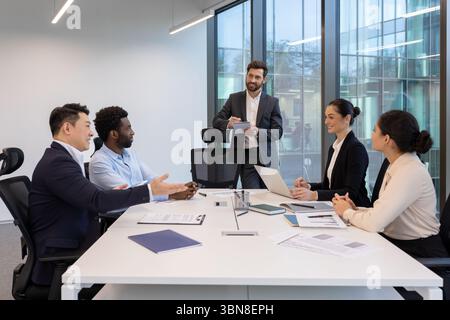 Eine vielfältige Gruppe von Geschäftsleuten in einer modernen Büroumgebung, die an einem gemeinsamen Meeting an einem Konferenztisch teilnahmen. Stockfoto