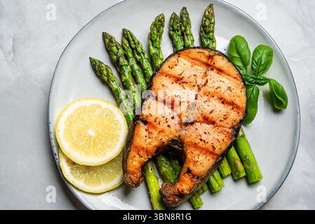Gegrilltes Lachsfischsteak über gegrilltem Spargel, Blick von oben. Ausgewogene Keto-Mahlzeit, gesundes Mittagessen. Stockfoto