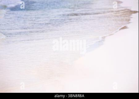 Ruhige Strandwellen plätschern sanft an einem wunderschönen Sandstrand und schaffen Frieden und Ruhe Stockfoto