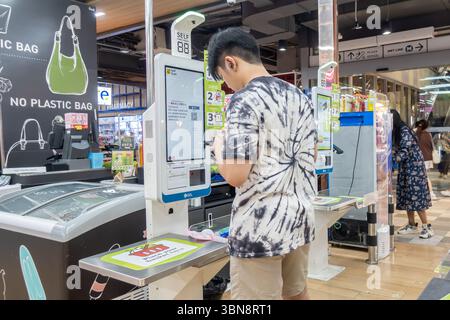 Big C Supermarkt, Bangkok, Thailand, Eine Person benutzt einen Selbstkasse-Kiosk, Scan & Pay, in einem Geschäft mit 'No Plastic Bag' Schildern. Stockfoto