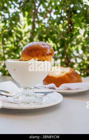 Traditionelle sizilianische Granita serviert mit einem klassischen Brioche „Col Tuppo“. Ein erfrischendes, gefrorenes Dessert, perfekt für ein Sommerfrühstück oder ein süßes Vergnügen Stockfoto