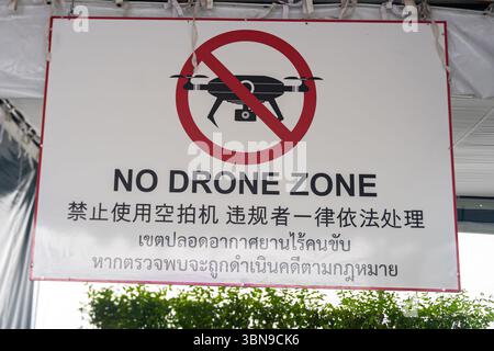Ein Schild ohne Drohne mit Warnungen auf Englisch, Chinesisch und Thai. Bangkok, Thailand Stockfoto