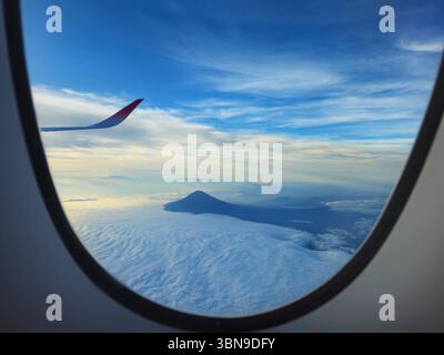 Flugzeugfenster Blick auf den Fuji über dem Wolkenmeer Stockfoto