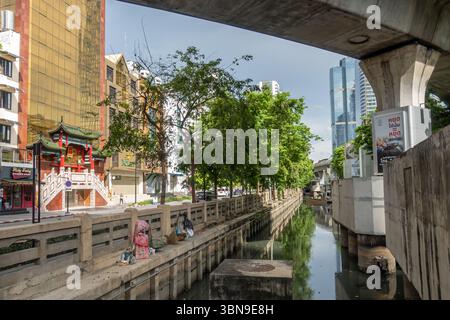 Ein mit Betondämmen gesäumter Kanal führt durch Bangkok Thailand mit einer Mischung aus traditioneller und moderner Architektur. Si Lom, Bang Rak, Bangkok Stockfoto