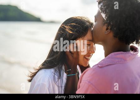 Reines Glück. Ein junges, vielseitiges, multiethnisches Paar genießt jeden Moment ihres tropischen Urlaubs Stockfoto