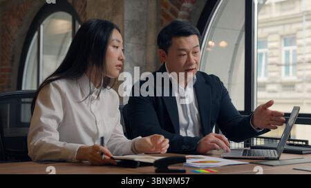 Geschäftsproblem Kollegen im Büro seriöser Chef Asiatischer Mann Geschäftsmann Führer männlicher Guy Mentor zeigt Fehlerdokumente melden Laptop reden Stockfoto