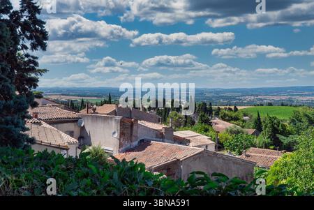 Ein Blick auf die Dächer einer kleinen Stadt im Süden Frankreichs. Die Häuser sind aus Stein und haben rosafarbene Dächer. Stockfoto