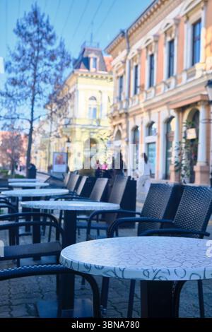 Leere Kaffeetische im Freien auf der europäischen Straße Stockfoto