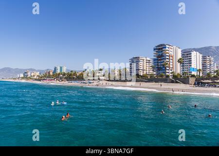 Mahmutlar, Türkei - 13. August 2024: Malerischer Blick auf einen Küstenort mit modernen Gebäuden, Sandstrand, Palmen und Menschen, die den tran genießen Stockfoto