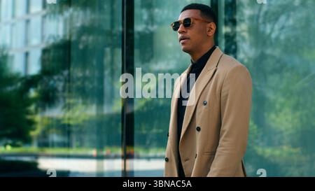 Ethnischer stilvoller, modischer, selbstbewusster afroamerikanischer Geschäftsmann, der draußen in der Stadt steht und schwarze Sonnenbrille trägt Geschäftsmann Guy männlich Stockfoto