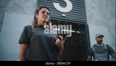 Multiethnische Mitarbeiter bringen Kartons mit Online-Bestellungen, E-Commerce-Waren zum Logistics Retail Warehouse. Weibliche Inventory Manager scannt Pakete mit Barcode-Scanner mit Tablet-Computer. Stockfoto