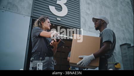 Verschiedene Mitarbeiter, die Kartons zum Logistics Distribution Warehouse transportieren. Weibliche Manager scannt Pakete mit Barcode-Scanner mit Digital Tablet. Online-Bestellungen, Lieferung, E-Commerce-Waren. Stockfoto