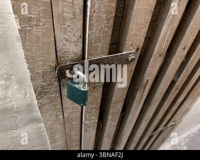 Geschlossenes altes Schloss an der Holztür im Keller des europäischen Hauses Stockfoto