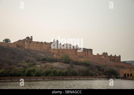 Das majestätische Amber Fort erhebt sich über den ruhigen Gewässern des Maota Lake in Jaipur, Rajasthan, und zeigt die reiche Geschichte und atemberaubende Architektur der Region Stockfoto