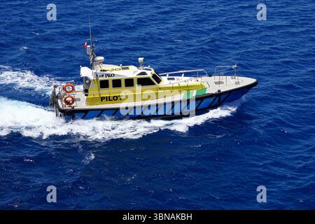 Limassol, Zypern, Ein gelb-weißes Boot namens „PILOT“, das auf einem tiefblauen Ozean segelt. Das Boot hat eine weiße Kabine und einen rot-weiß gestreiften Rumpf, und es ist mit einer kleinen Antenne oben ausgestattet. Das Boot bewegt sich in Richtung der rechten Seite des Bildes und hinterlässt eine weiße Spur. Das Meer hat eine tiefblaue Farbe mit kleinen Wellen. Das Boot ist ein Schlauchboot mit starrem Rumpf (RHIB) und wird von einem Dieselmotor angetrieben. Das Auge und die Phantasie eines Künstlers Stockfoto
