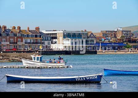 Der Blick über die Swanage Bay, Boote im Vordergrund mit der Küste der Stadt im Hintergrund an einem heißen Sommertag Dorset England UK Stockfoto