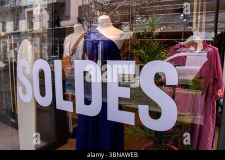 Schaufensterausstellung eines Bekleidungsgeschäfts in Paris, Frankreich, während des Verkaufszeitraums mit dem französischen Wort „SOLDES“ in weißen Großbuchstaben Stockfoto