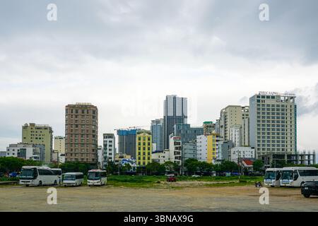 Da Nang, Vietnam-19. März 2025: Ein Weitwinkelblick auf das da Nang Hotelviertel mit vielfältiger Architektur und Bussen, die unter einem bewölkten Himmel geparkt sind. Stockfoto