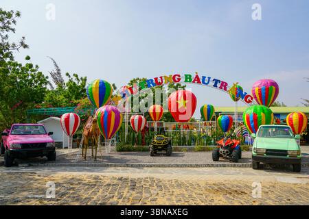 Mui ne, Vietnam - 21. März 2025: Ein lebhafter Eingang zum Khu du lich Bau Trang mit farbenfrohen Heißluftballons, Geländefahrzeugen und dekorativen Fahrzeugen Stockfoto