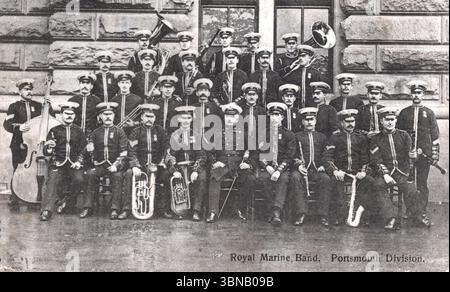 Die Royal Marine Band, Portsmouth Division, posiert in voller Uniform vor einem Steingebäude. Die Musiker sind in drei Reihen angeordnet und halten Instrumente wie Kontrabass, Tuba, Posaune, Trompete, Saxophon, und Klarinette. Die formale Komposition spiegelt militärische Präzision und musikalischen Stolz wider. Von einer Originalpostkarte, die Rosemont um 1910 veröffentlichte. Stockfoto