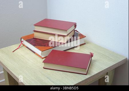 Stapel Bücher auf einem Tisch in einem Gästezimmer Stockfoto