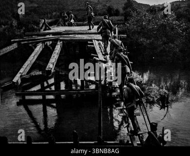 Eine lange Linie von Ochsenwagen der rückziehenden serbischen Armee überquert überflutetes Gelände in der Bagrad-Schlucht nordöstlich von Kragujevac während des Ersten Weltkriegs. Untergetaucht vom geschwollenen Fluss Morava zwang die Talroute die Truppen, durch hohe Gewässer zu navigieren. Dieses eindrucksvolle Bild, das von einem Eisenbahndamm stammt, veranschaulicht die Not des Rückzugs Serbiens von 1915. Veröffentlicht in L’Illustration, 1. Januar 1916. Stockfoto