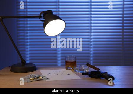 Mafia und kriminelle Welt. Pistole, Zigarre, Whiskey, Fingerabdrücke, Geld und Kugeln auf Holztisch drinnen Stockfoto