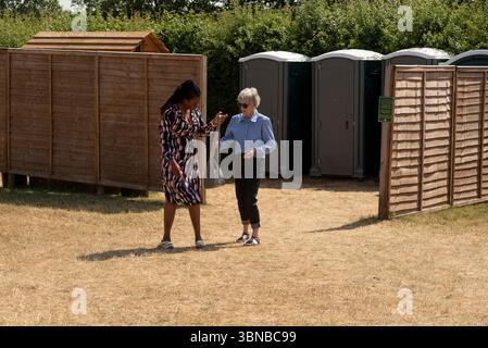 Gloucestershire England Vereinigtes Königreich. 30.06.2025. Betreuer und Patient auf einem Landausflug mit einem Hintergrund von Toilettenanlagen außerhalb des Blocks, der für p Stockfoto