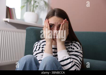 Besorgte Frau, die zu Hause an Paranoia leidet Stockfoto