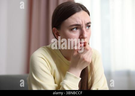 Verängstigte Frau, die zu Hause an Paranoia leidet Stockfoto