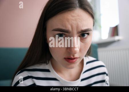 Verängstigte Frau, die zu Hause an Paranoia leidet Stockfoto