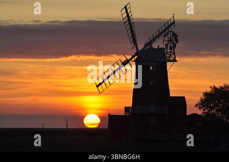 Sonnenaufgang hinter der Mühle in Cley-next-the-Sea Norfolk England. Stockfoto