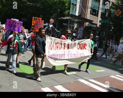 SEATTLE – 14. Juni 2025 – Anhänger der Rechte von Einwanderern, die Protestschilder halten und friedlich mit leidenschaftlichen Ausbrüchen durch die Innenstadt von Seattle marschieren Stockfoto