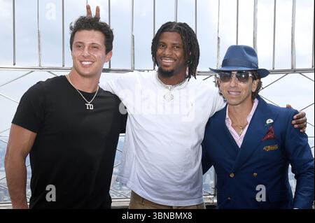 New York, USA. Juli 2025. (L-R) der New York Giants Quarterback Tommy DeVito, der New York Giants Wide Receiver Ihmir Smith-Marsette und der Sportagent Sean P. Stellato besuchen das Empire State Building, um die NFL Pre-Season in New York, NY, 1. Juli 2025 zu feiern. (Foto: Anthony Behar/SIPA USA) Credit: SIPA USA/Alamy Live News Stockfoto