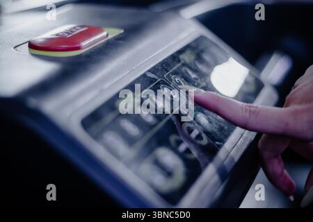 Detailaufnahme eines Fingers einer Frau, der die Taste „2“ auf dem Bedienfeld des Laufbands drückt. Konzentrieren Sie sich auf die Einstellung der Geschwindigkeit für eine Fitnessaktivität in Innenräumen. Stockfoto