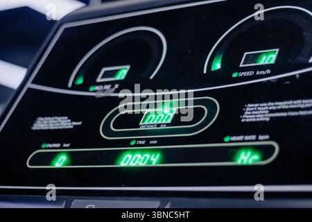 Eine Nahaufnahme, die die digitale Anzeige eines Laufbands zeigt und Kennzahlen wie Geschwindigkeit, Distanz, Zeit, Herzfrequenz und Kalorienbu hervorhebt Stockfoto