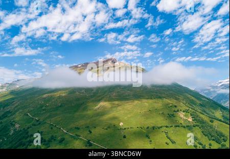 Wunderschöne grüne Berglandschaft mit Wolken, die tagsüber über über den Gipfeln hängen, in ruhiger Lage Stockfoto