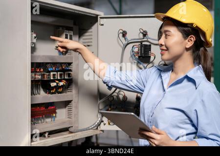 Mechaniker, Instandhaltungs- oder Elektroingenieur, der die wichtigsten Industrieanlagen für elektrische Steuersysteme überprüft. Versorgungsunternehmen vor Mann tägliche Überprüfung der Stromversorgungssysteme i Stockfoto