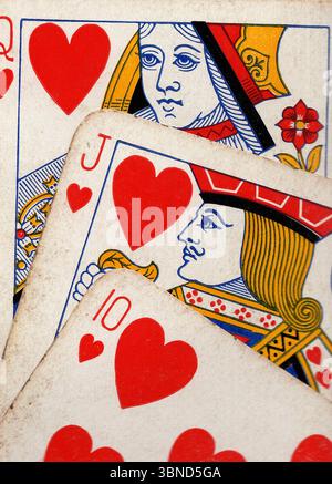 Details aus einer Hand von Vintage-Spielkarten im Anzug der Herzen. Stockfoto