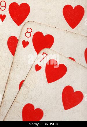 Details aus einer Hand von Vintage-Spielkarten im Anzug der Herzen. Stockfoto