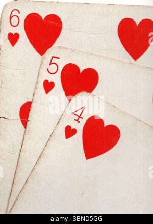 Details aus einer Hand von Vintage-Spielkarten im Anzug der Herzen. Stockfoto