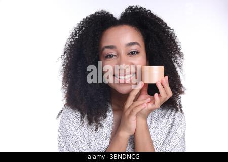 Schöne brasilianische Frau mit einem Glas Kollagencreme auf weißem Hintergrund Stockfoto